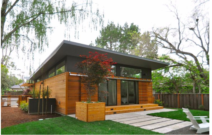 Sit back and relax in this contemporary container home’s brightly-lit living area